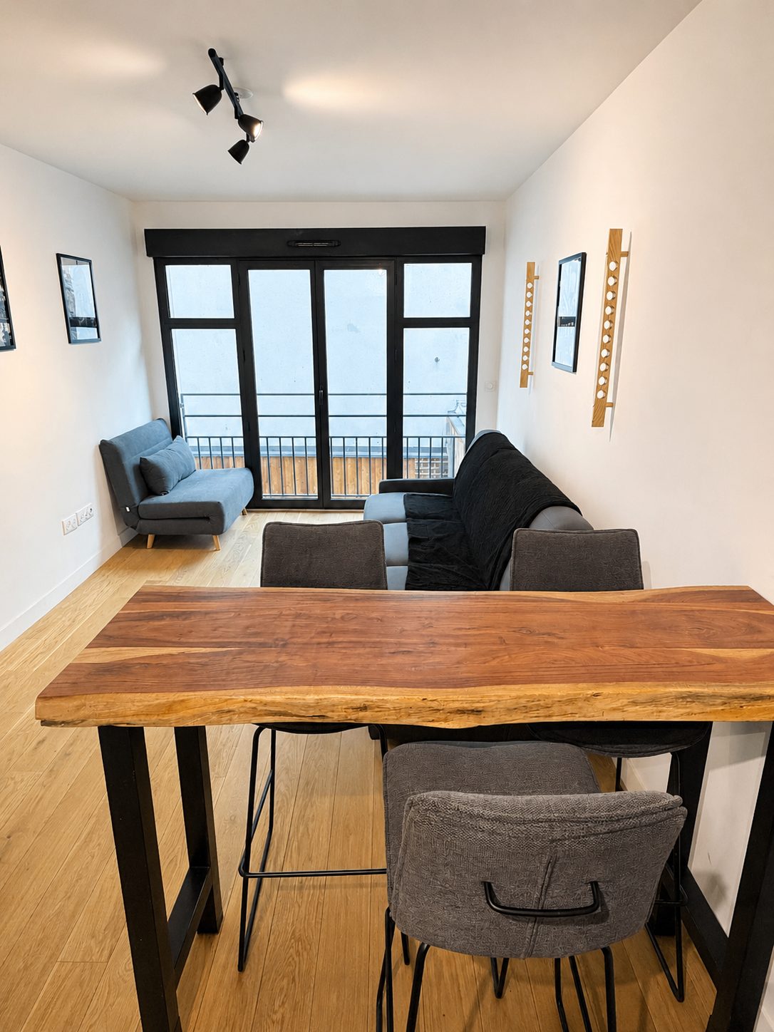 Vue d'ensemble du studio avec table à manger et baie vitrée